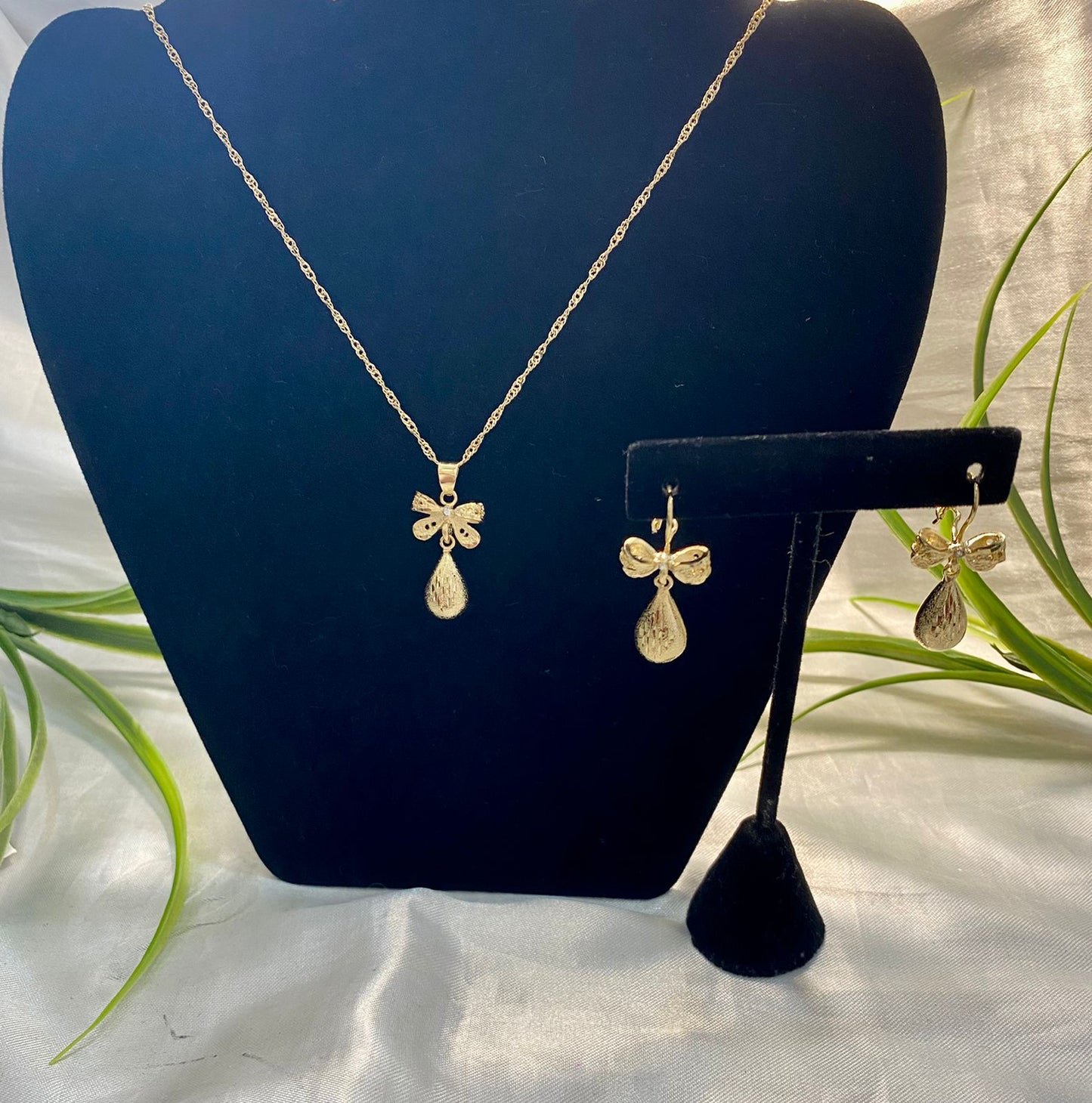 Juego de Cadena y aretes con dije moño y bule chico. Chapa de oro.