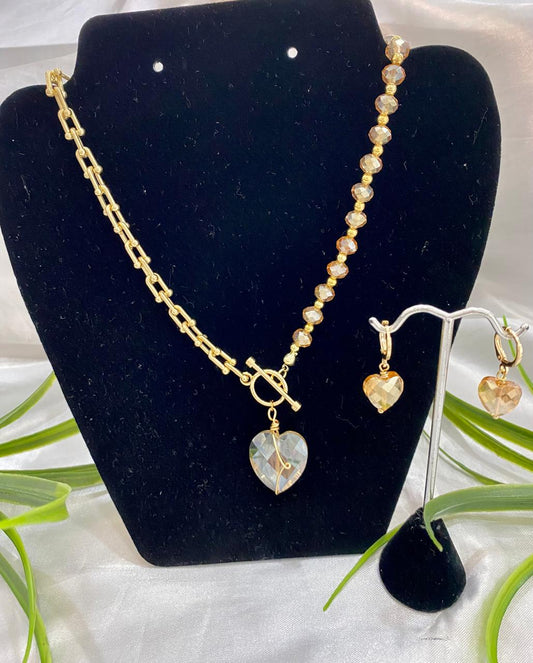 Juego de aretes y collar, mitad Cadena y mitad piedra con corazón de cristal miel.